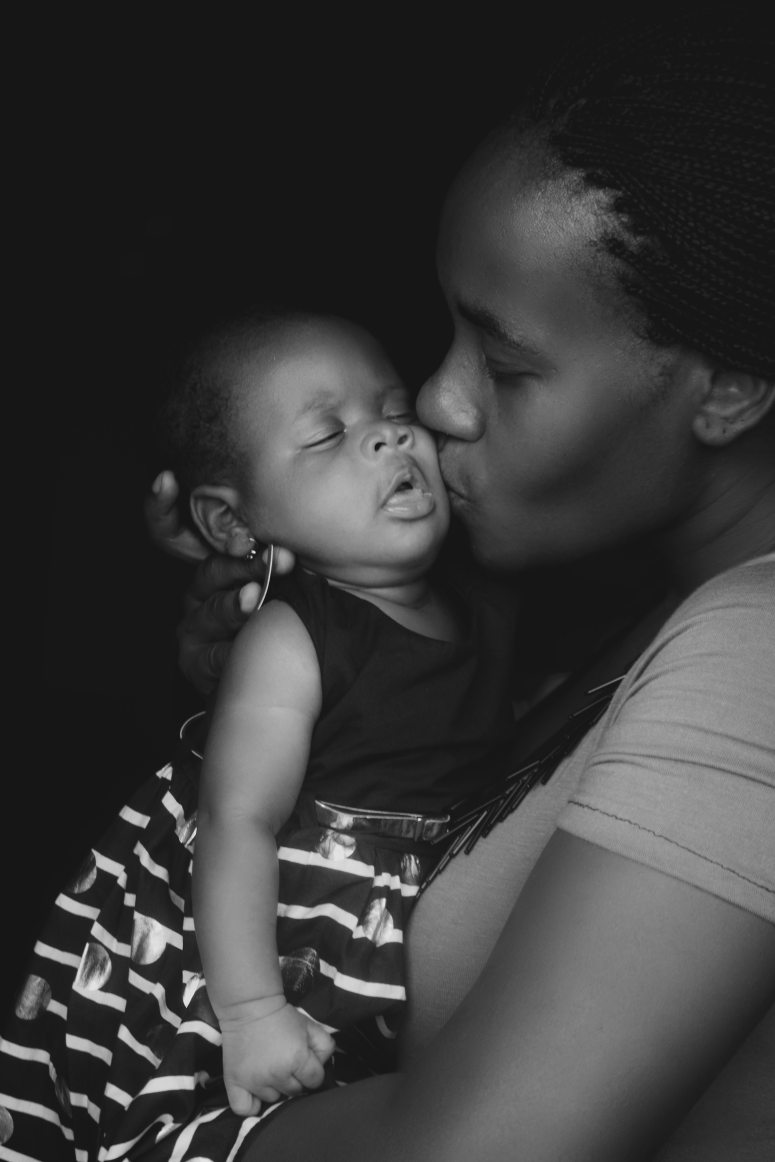 grayscale-photo-of-woman-kissing-child-3704379